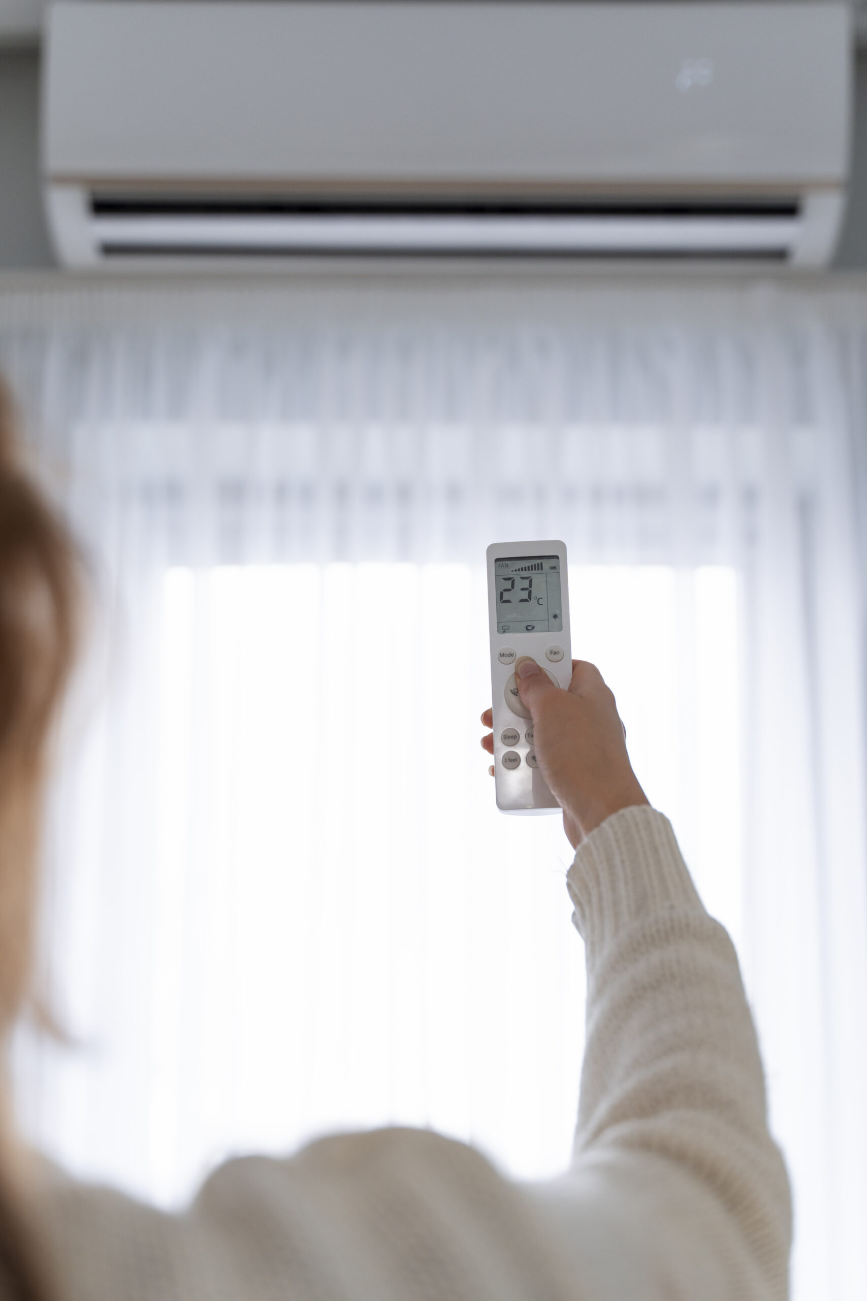 woman-holding-remote-start-heater Photo d'une femme tenant la télécommande du climatiseur